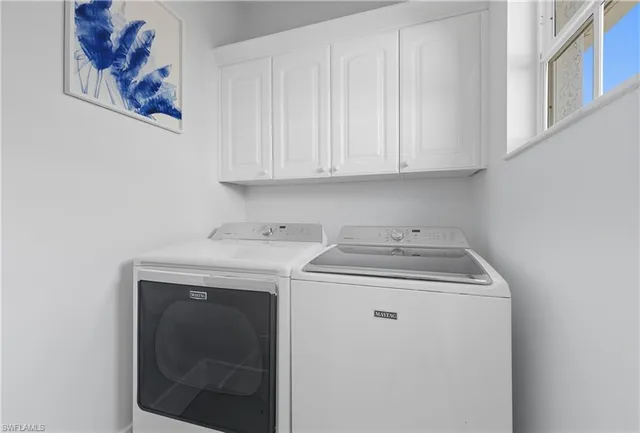 a living room with furniture tv and large windows