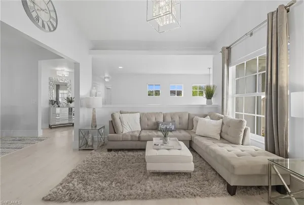 a living room with furniture and a view of kitchen