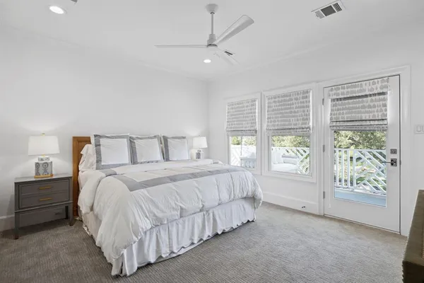 a bedroom with a large bed and a chandelier fan