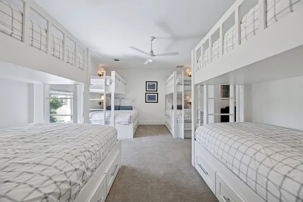 a spacious bedroom with a large bed and a chandelier