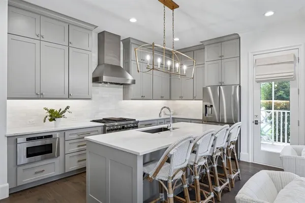 a kitchen with stainless steel appliances a stove a table and chairs