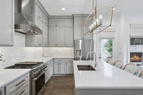 a kitchen with stainless steel appliances granite countertop a sink a stove and a refrigerator
