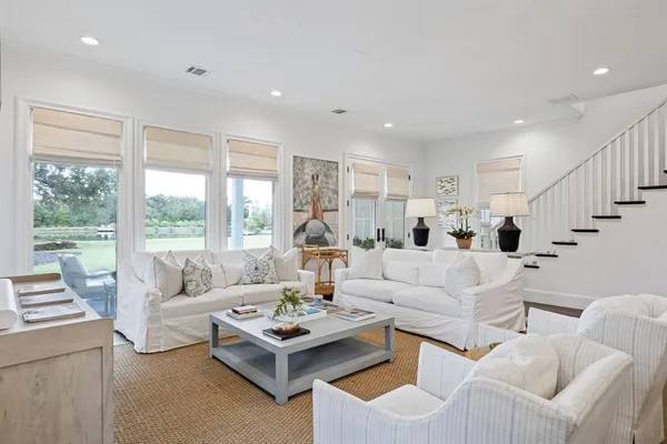 a living room with furniture potted plant and a large window