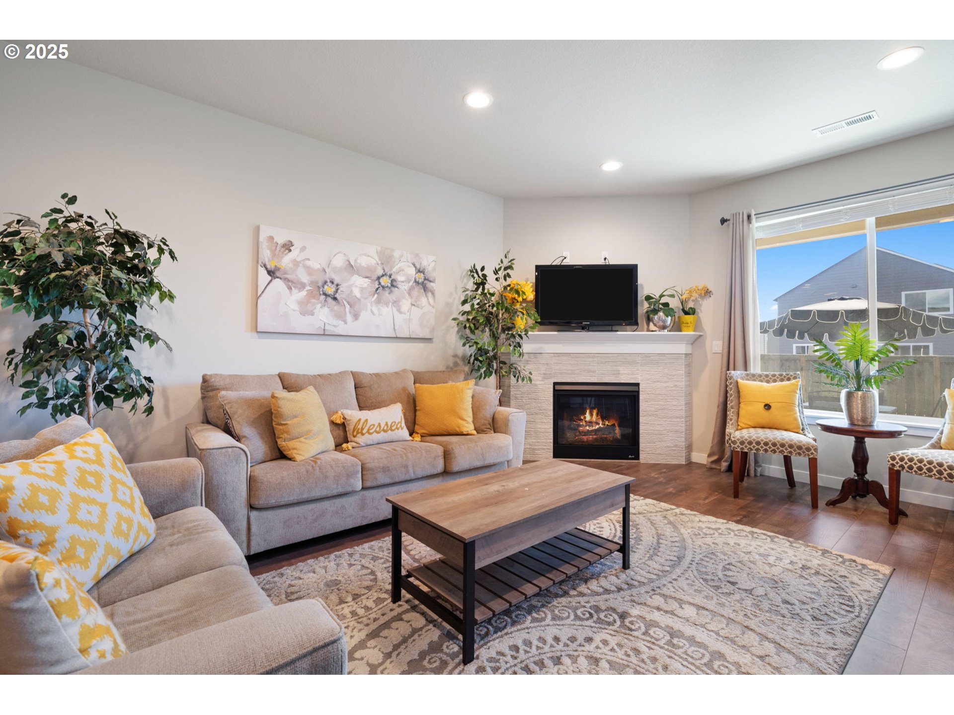 8707 North 1st Street Ridgefield, WA 98642 - Photo 4 of 40 a living room with furniture a flat screen tv and a fireplace