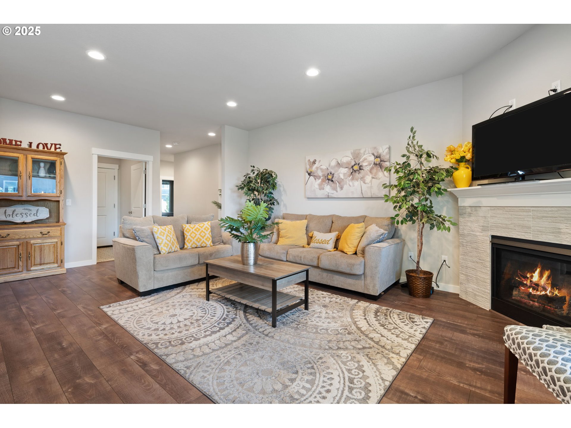 8707 North 1st Street Ridgefield, WA 98642 - Photo 6 of 40 a living room with furniture a flat screen tv and a fireplace