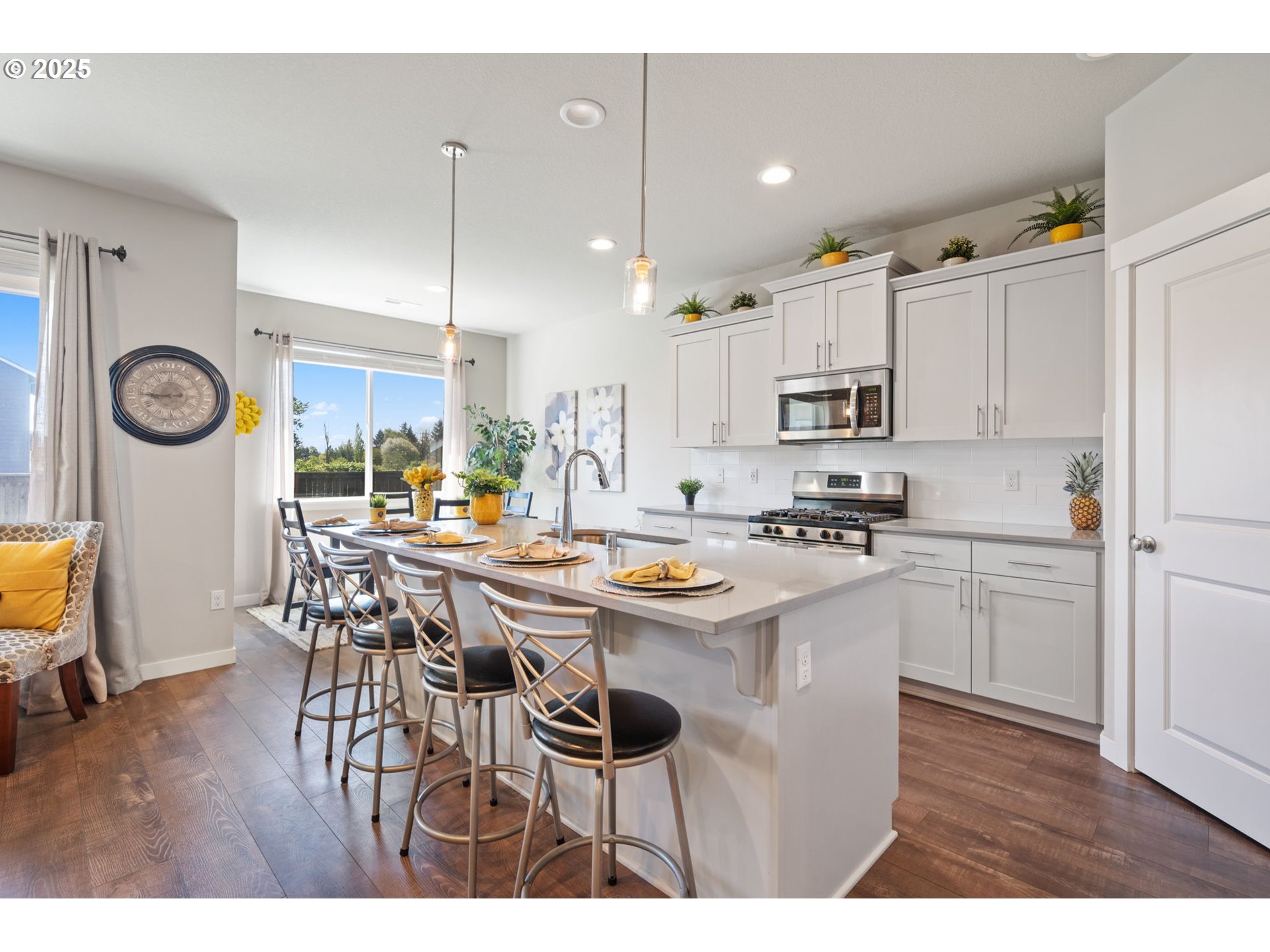 8707 North 1st Street Ridgefield, WA 98642 - Photo 9 of 40 a kitchen with kitchen island granite countertop a table chairs a sink dishwasher refrigerator and cabinets