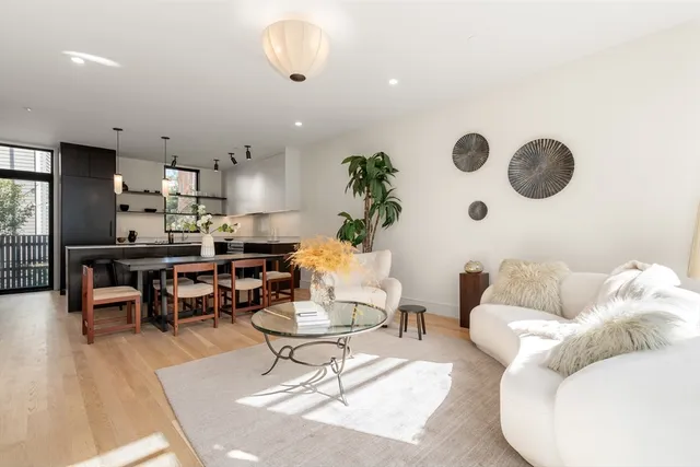 a kitchen with stainless steel appliances granite countertop a dining table and chairs with wooden floor