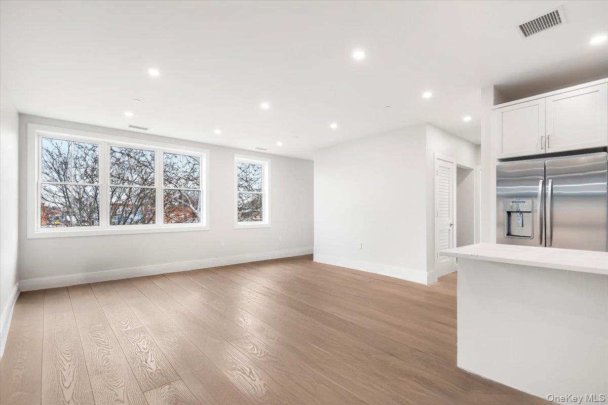 132 Halstead Avenue, Unit B Harrison, NY 10528 - Photo 5 of 19 an empty room with wooden floor and windows