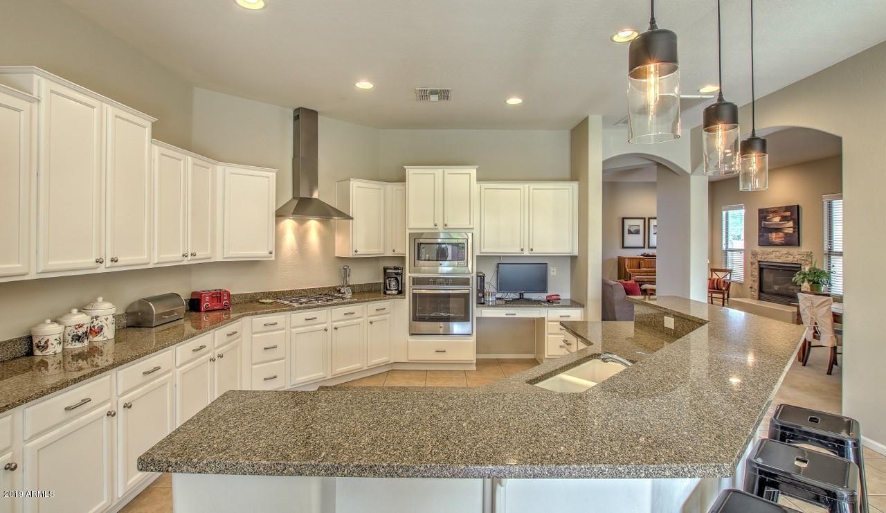 3977 East Hashknife Road Phoenix, AZ 85050 - Photo 11 of 28 a kitchen with stainless steel appliances granite countertop a sink stove and cabinets