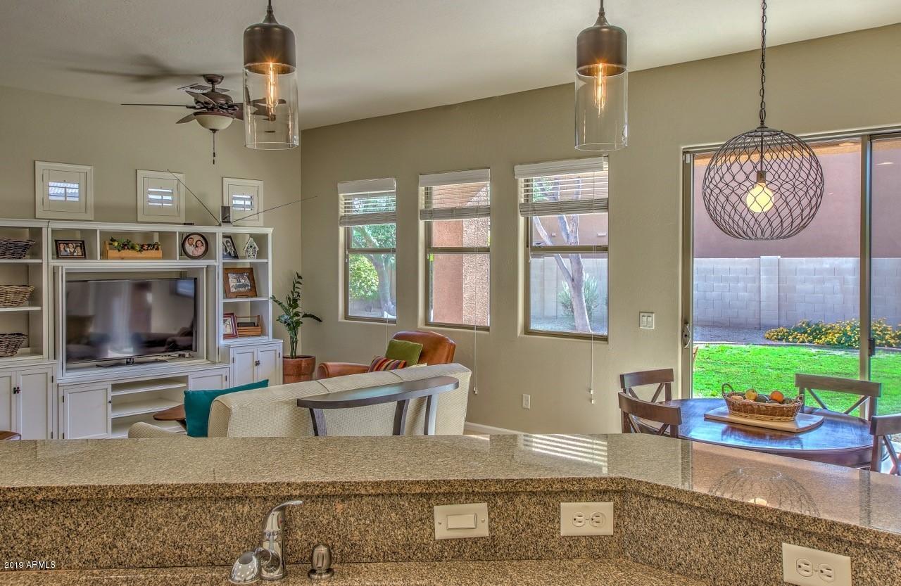 3977 East Hashknife Road Phoenix, AZ 85050 - Photo 12 of 28 a living room with furniture a flat screen tv and a fireplace