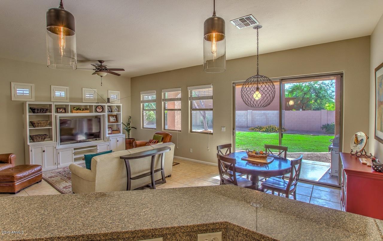 3977 East Hashknife Road Phoenix, AZ 85050 - Photo 8 of 28 a living room with fireplace furniture and a chandelier