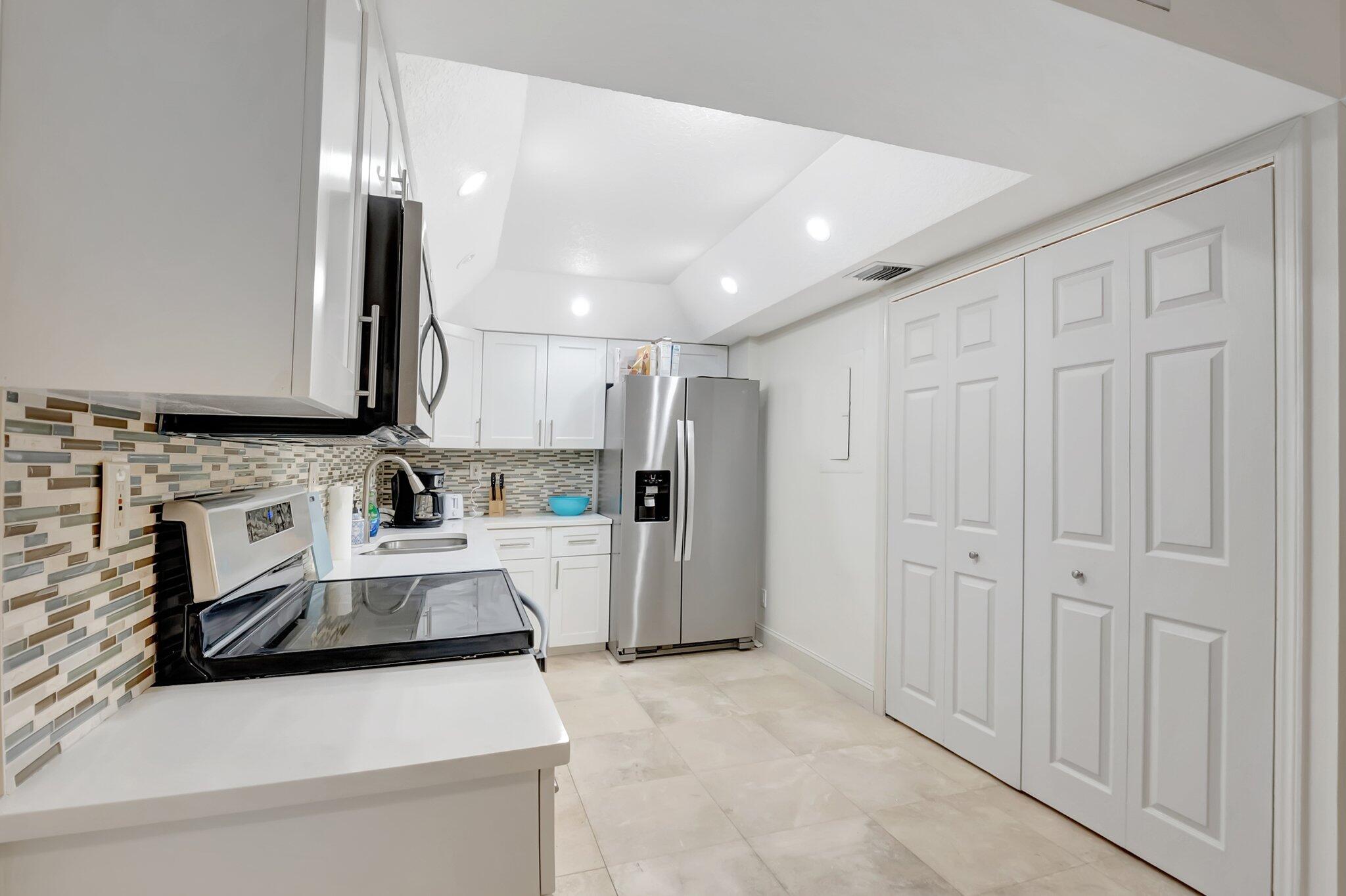 7370 Orangewood Lane, Unit 107 Boca Raton, FL 33433 - Photo 12 of 78 a kitchen with stainless steel appliances a refrigerator sink and cabinets
