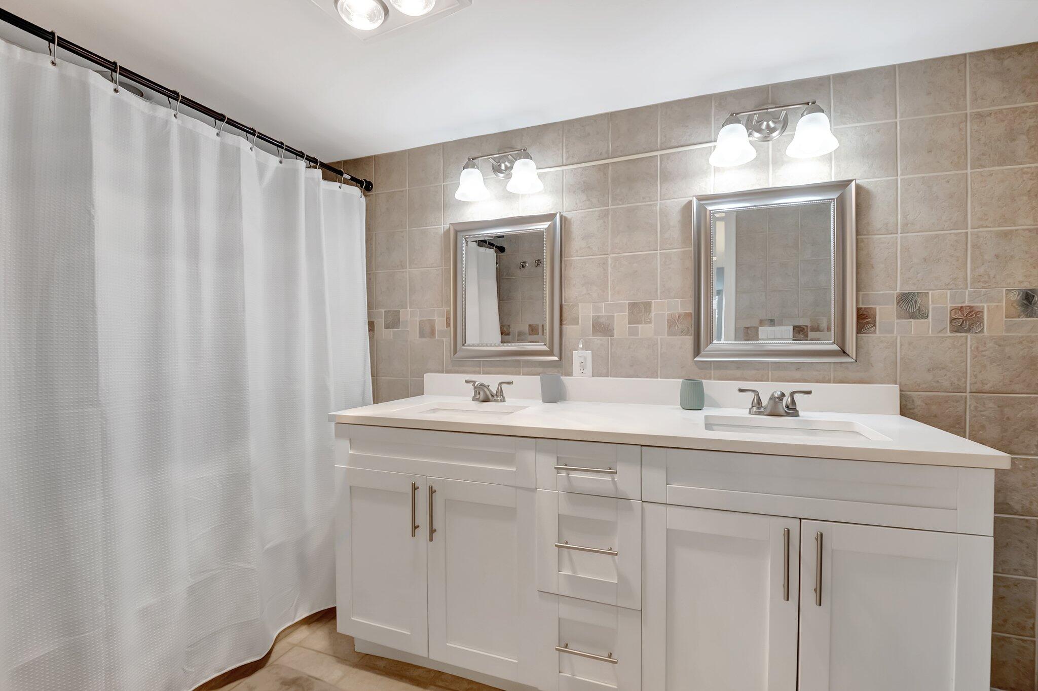 7370 Orangewood Lane, Unit 107 Boca Raton, FL 33433 - Photo 20 of 78 a bathroom with a double vanity sink and mirror