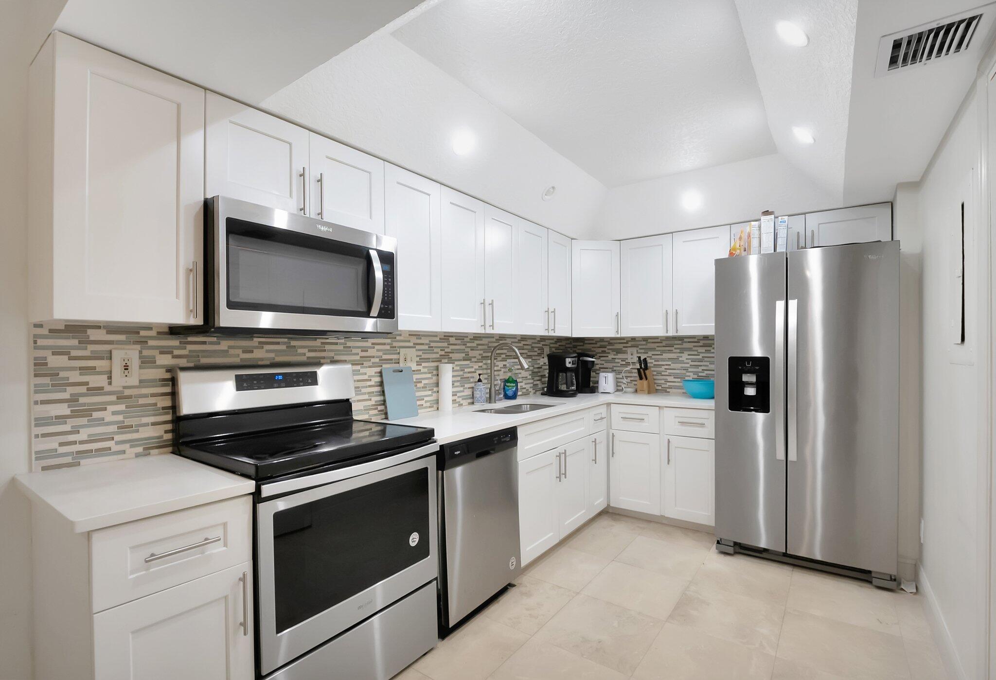 7370 Orangewood Lane, Unit 107 Boca Raton, FL 33433 - Photo 2 of 78 a kitchen with cabinets stainless steel appliances and sink