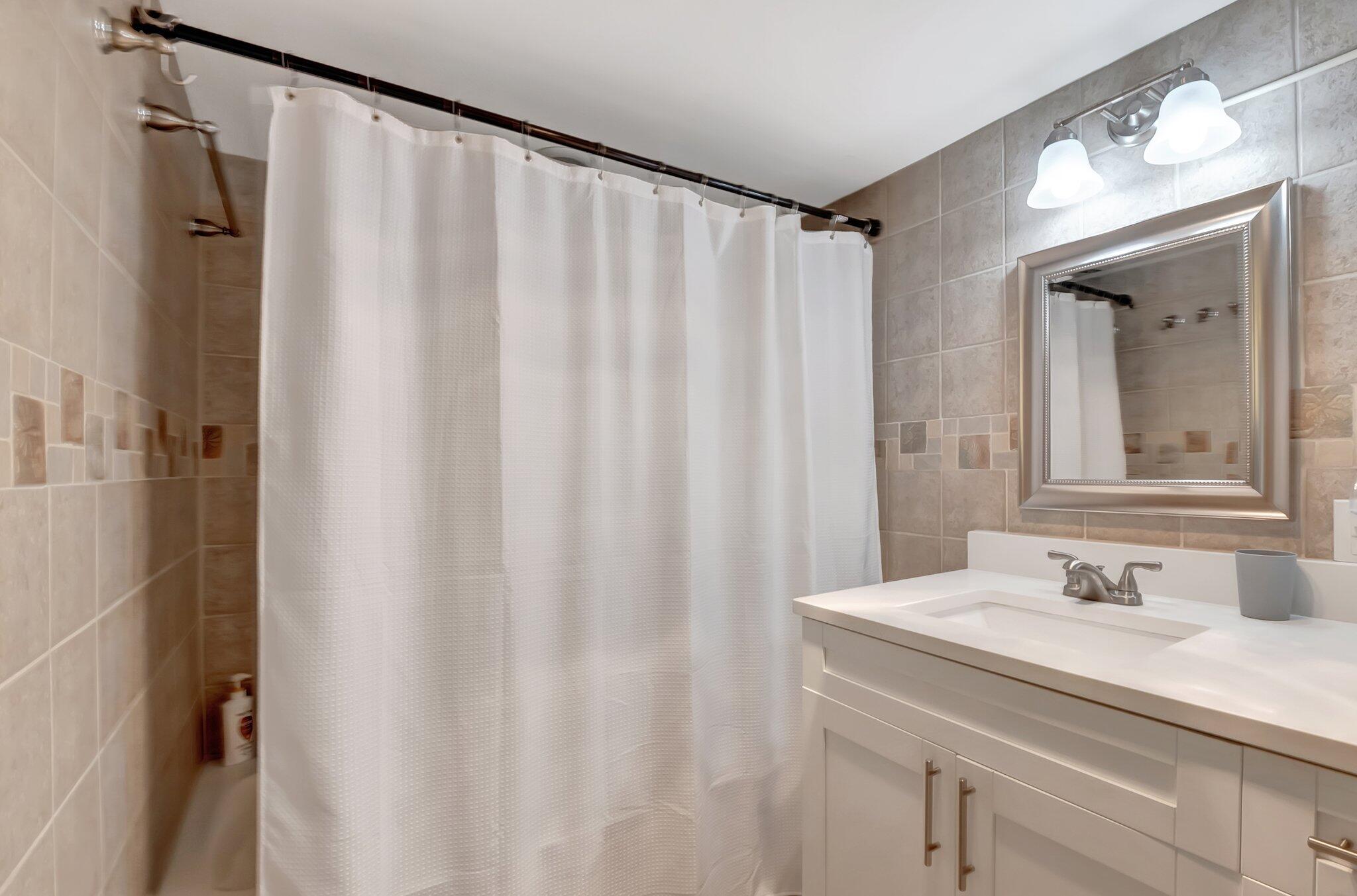7370 Orangewood Lane, Unit 107 Boca Raton, FL 33433 - Photo 21 of 78 a bathroom with a sink and a mirror