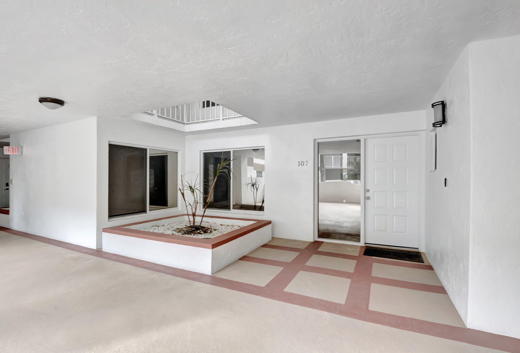 7370 Orangewood Lane, Unit 107 Boca Raton, FL 33433 - Photo 29 of 78 a view of a livingroom with wooden floor and white walls