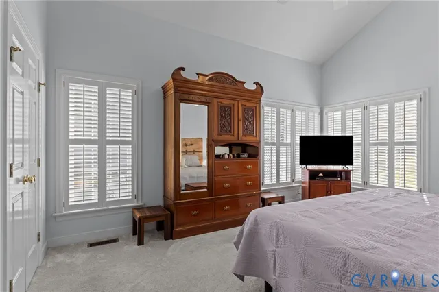 a bedroom with a bed and a flat tv screen on wall