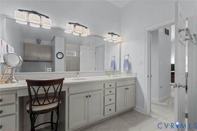 a spacious bathroom with a granite countertop sink a toilet a mirror and shower