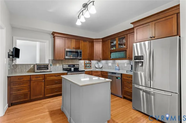 a kitchen with stainless steel appliances granite countertop a refrigerator stove microwave and sink