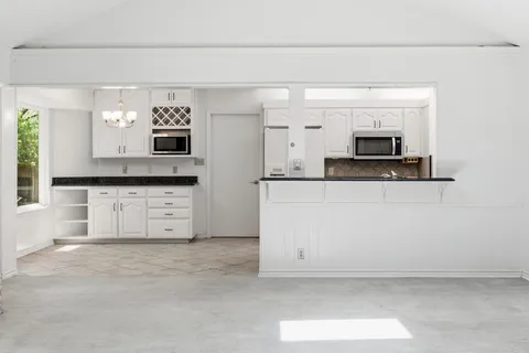 a view of kitchen with a sink and chandelier
