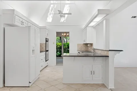 a kitchen with granite countertop white cabinets stainless steel appliances and a sink