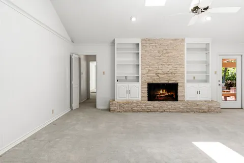 an empty room with windows and fireplace