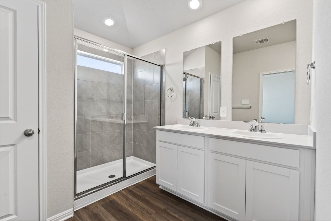 145 Honey Bee Road Jarrell, TX 76537 - Photo 16 of 27 a bathroom with a shower sink and mirror