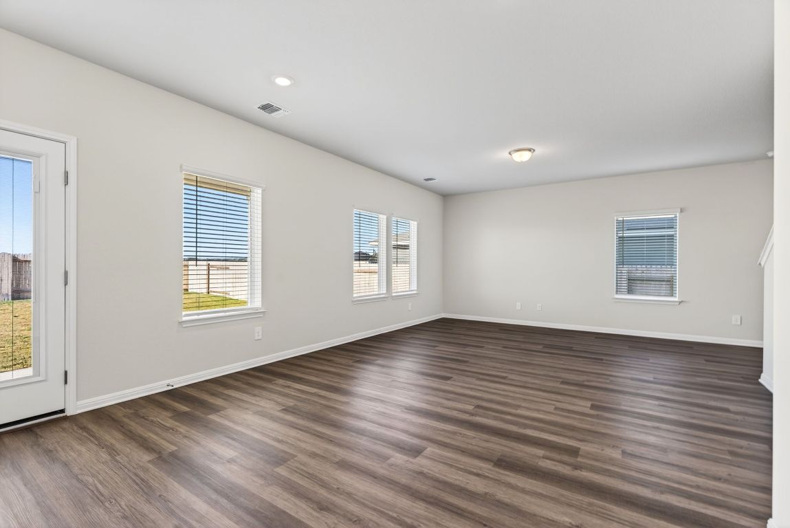 145 Honey Bee Road Jarrell, TX 76537 - Photo 4 of 27 a view of an empty room with wooden floor and a window