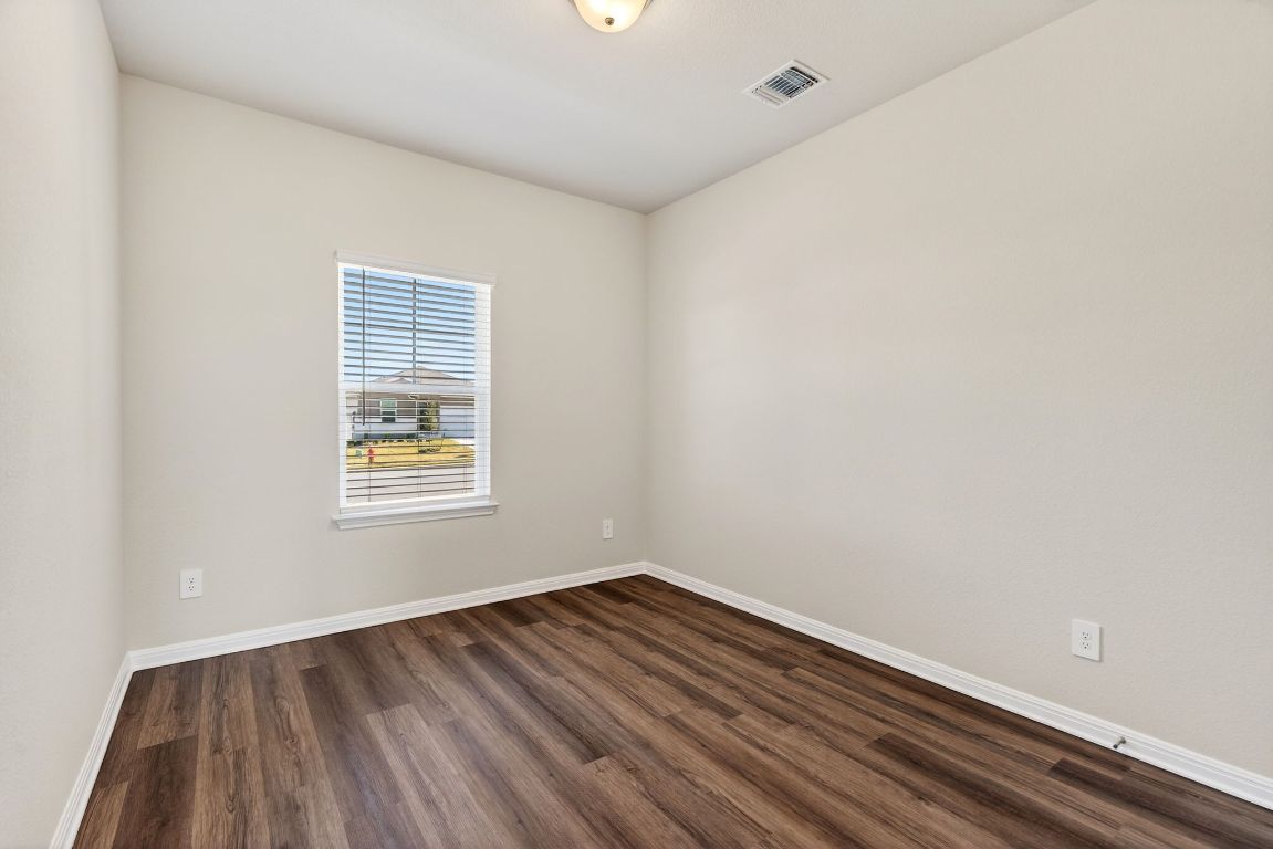 145 Honey Bee Road Jarrell, TX 76537 - Photo 9 of 27 a view of an empty room with wooden floor and a window