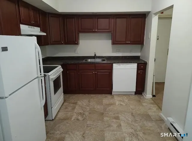 a view of kitchen with a sink and a refrigerator