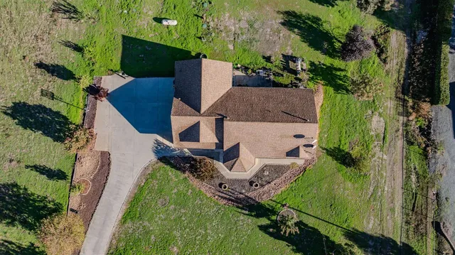 an aerial view of a house with a yard and lake view