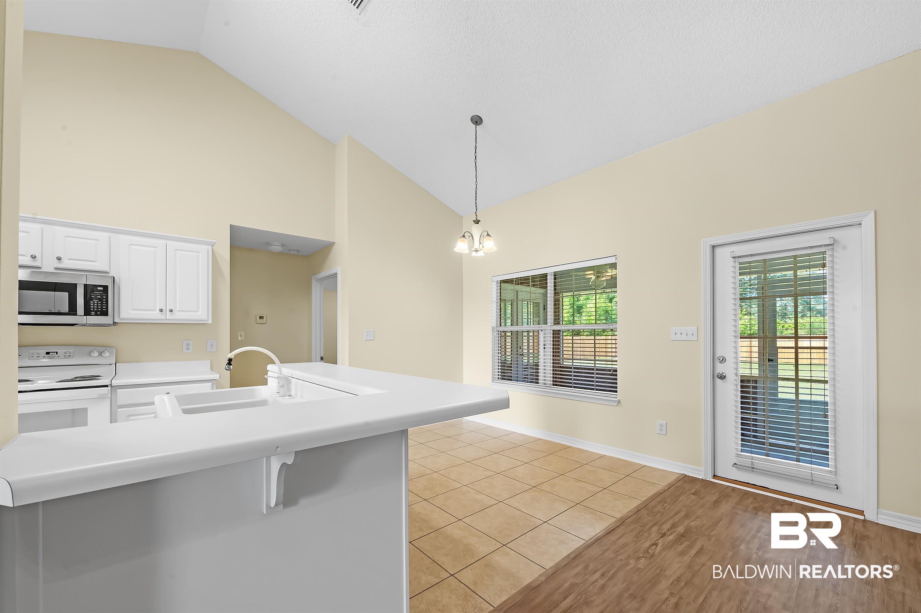 12443 Venice Boulevard Foley, AL 36535 - Photo 37 of 59 Kitchen with vaulted ceiling, decorative light fixtures, light hardwood / wood-style flooring, sink, and white range with electric stovetop