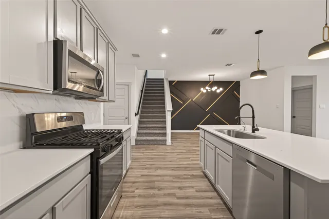 a kitchen with kitchen island a sink appliances and cabinets