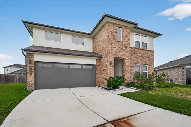 a front view of a house with garage and yard
