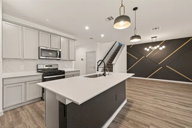 a kitchen with a stove a microwave and wooden floor