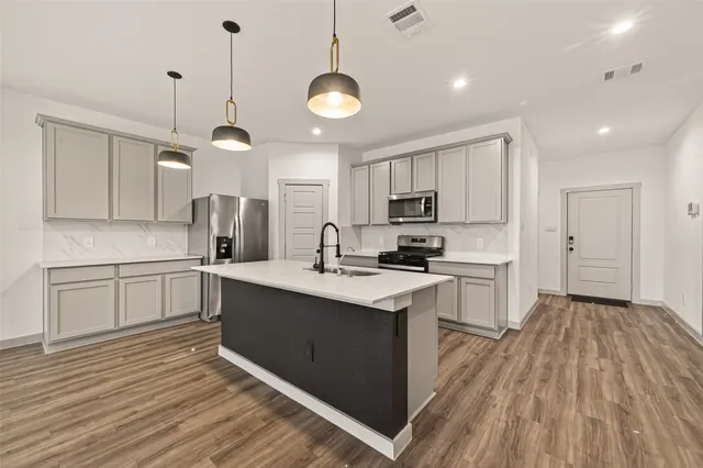a kitchen with refrigerator cabinets and wooden floor