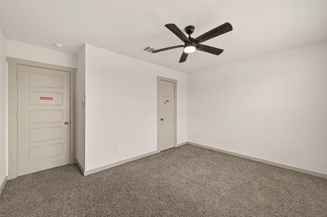 a view of a big room with closet and ceiling fan