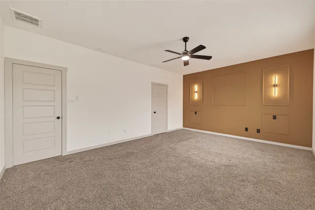 a view of an empty room with a ceiling fan