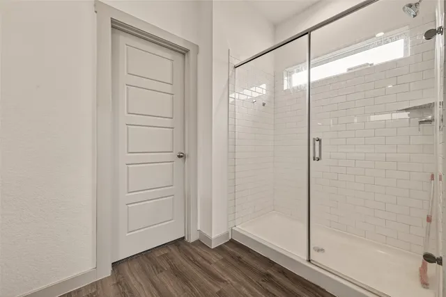 a bathroom with a shower and a glass door