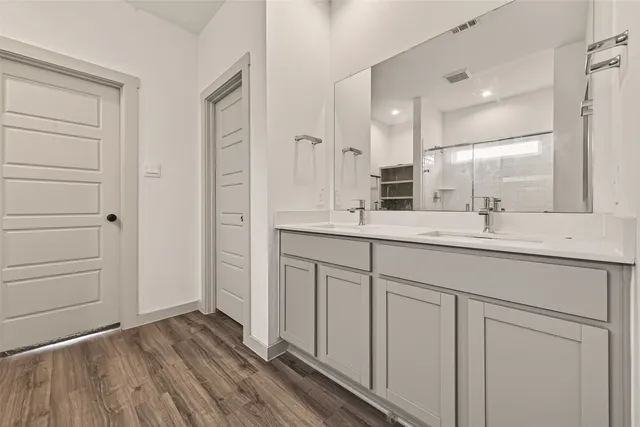 a bathroom with a double vanity sink a mirror and a shower