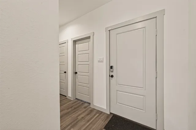 an empty room with wooden floor closet and door