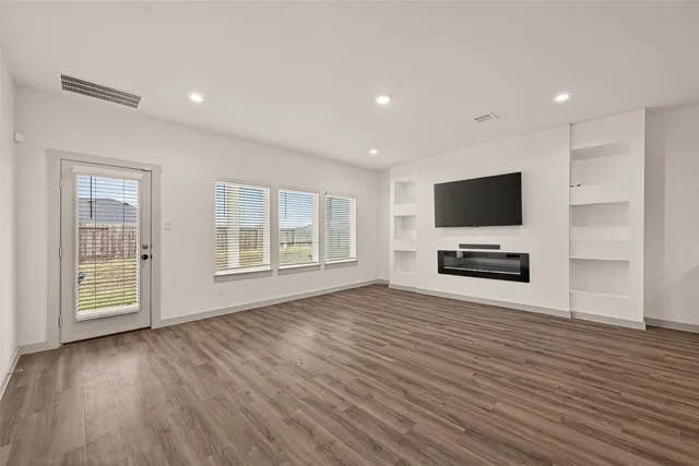 a view of room with wooden floor and flat screen tv