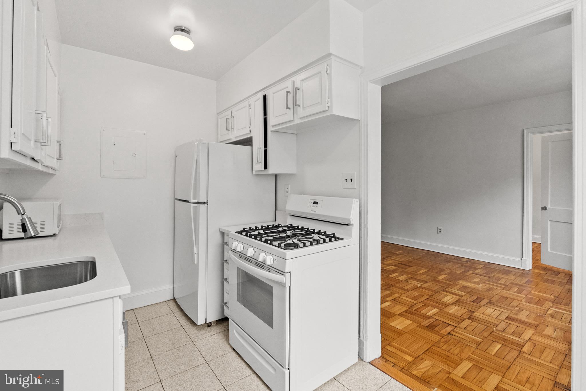 4491 MacArthur Boulevard Northwest, Unit 303 Washington, DC 20007 - Photo 12 of 37 a kitchen with a stove and a refrigerator