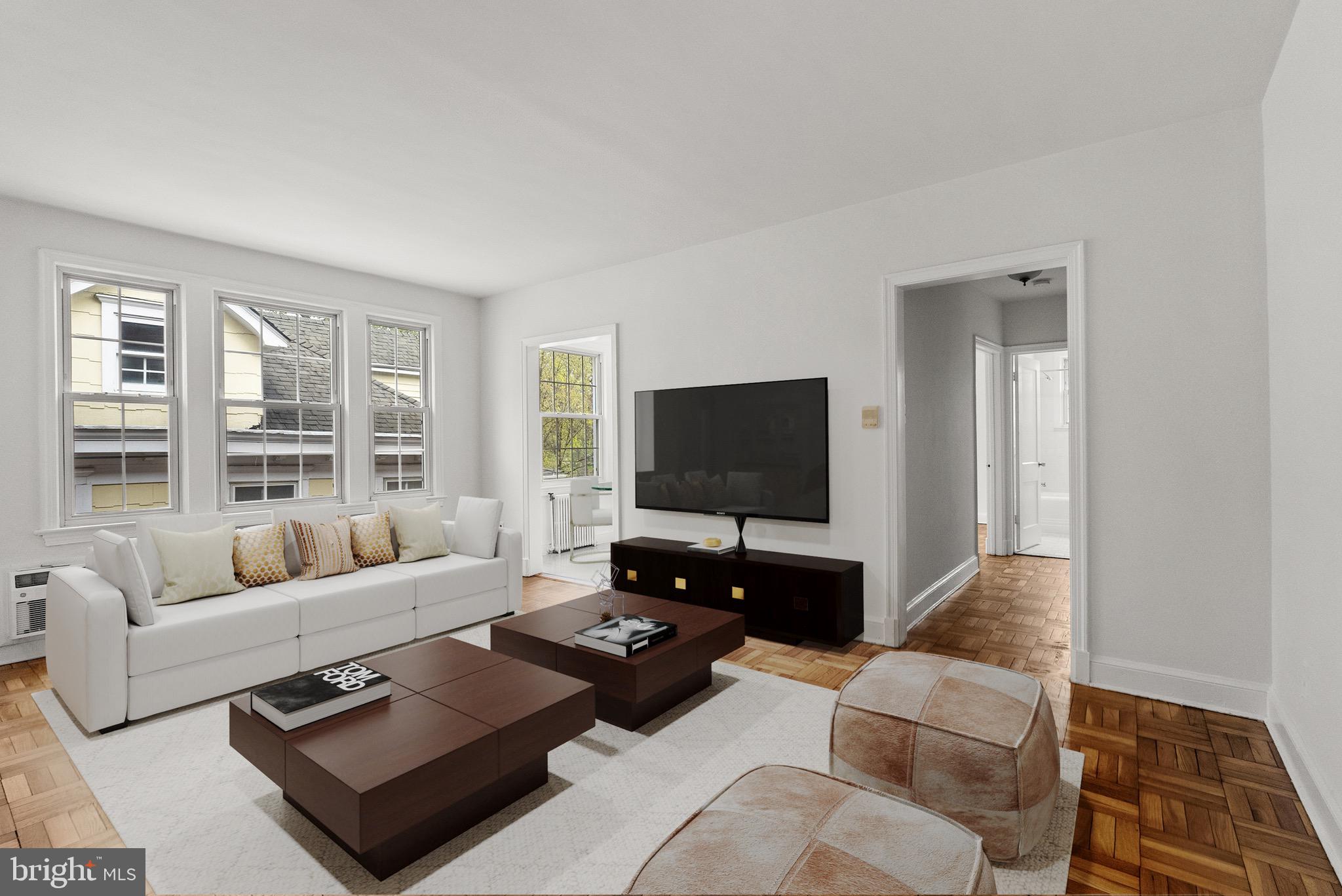 4491 MacArthur Boulevard Northwest, Unit 303 Washington, DC 20007 - Photo 2 of 37 a living room with furniture and a flat screen tv