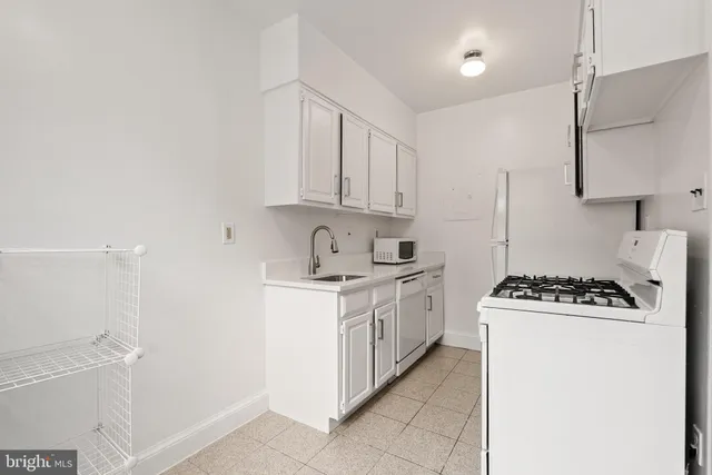 a kitchen with sink a stove and cabinets
