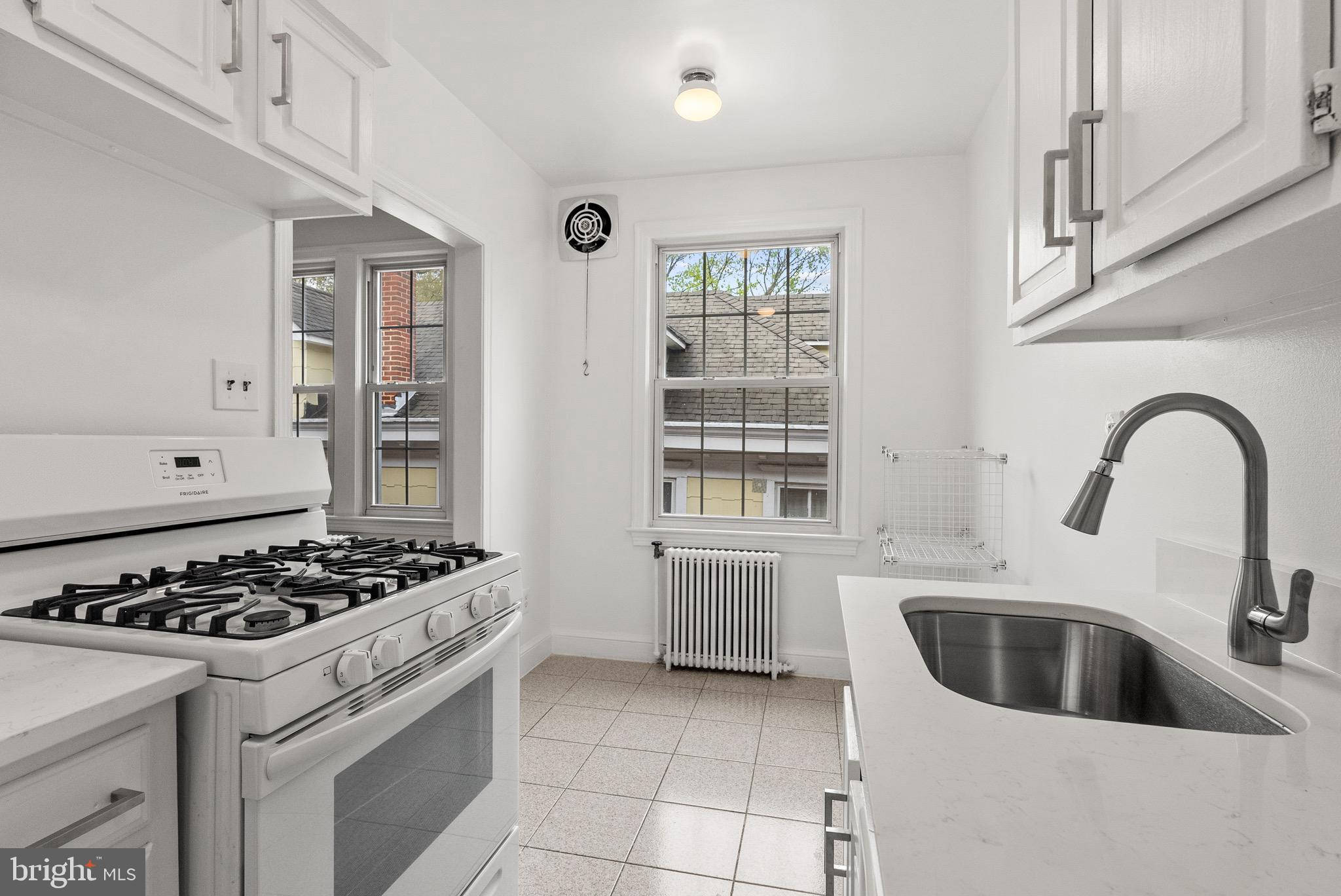 4491 MacArthur Boulevard Northwest, Unit 303 Washington, DC 20007 - Photo 9 of 37 a kitchen with a stove a sink and cabinets