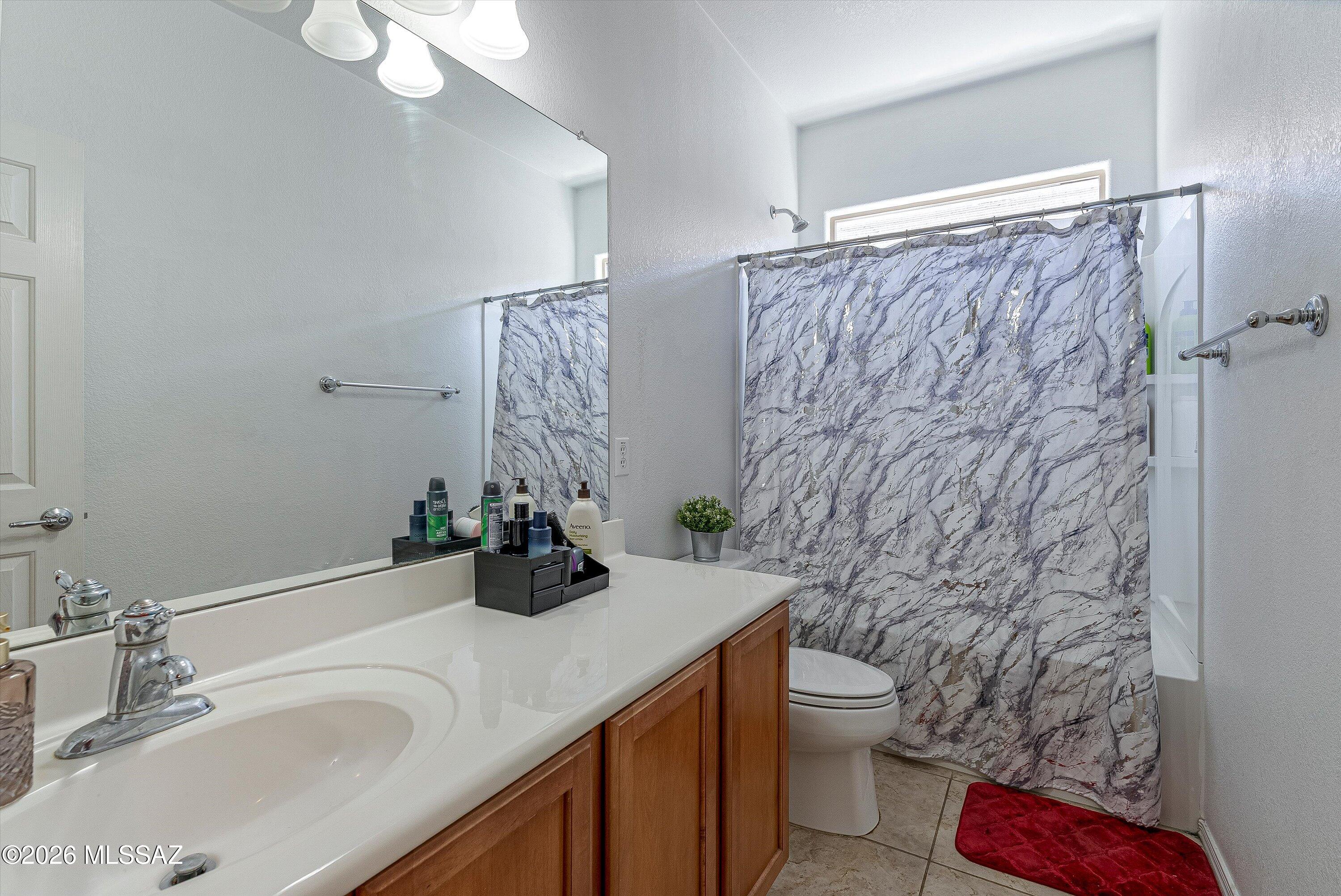 21163 East Treasure Road Red Rock, AZ 85145 - Photo 20 of 35 a bathroom with a sink a toilet and shower curtain