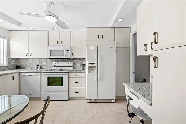 a kitchen with stainless steel appliances a stove refrigerator sink and white cabinets