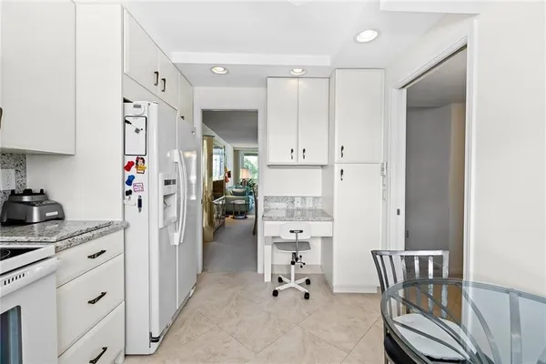 a kitchen with stainless steel appliances kitchen island granite countertop a refrigerator and cabinets