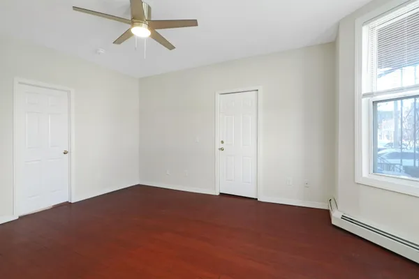 an empty room with windows and fan